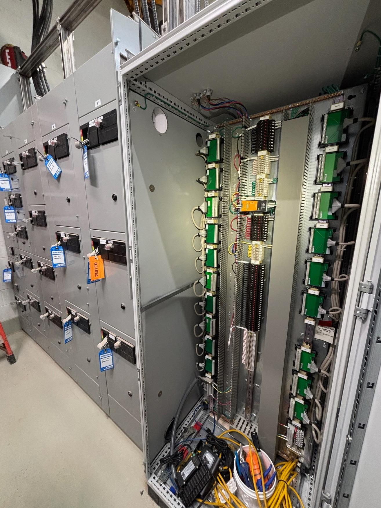 Motor control centre line-up beside an open PLC cabinet with wired I/O modules at Nutrien Allan Mine.