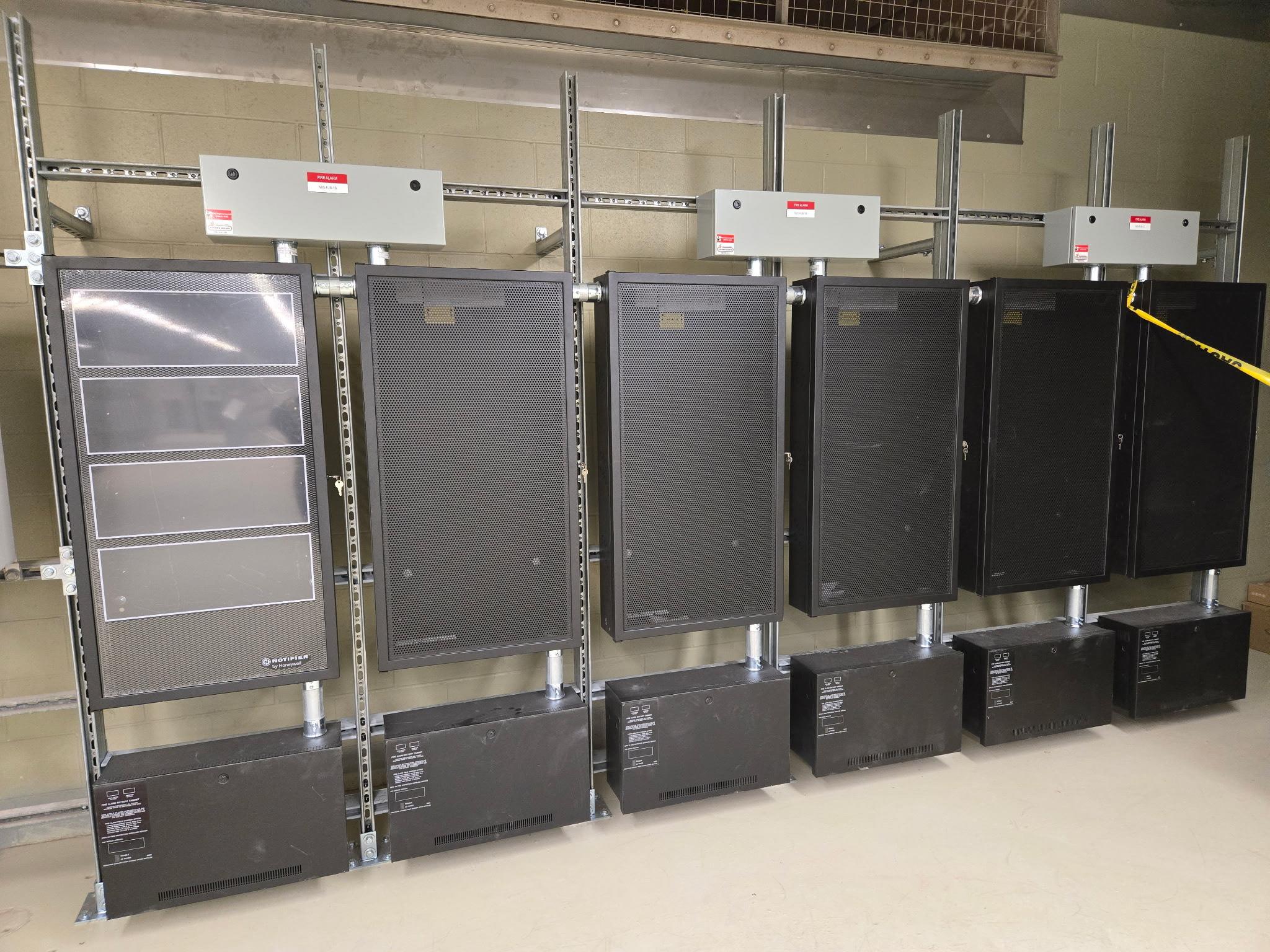 Row of Notifier fire alarm control panels with battery cabinets at Nutrien Cory Mine.
